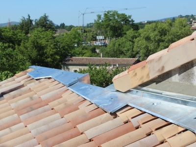 Faîtage monopente en zinc et traitement du raccord à la couverture en tuiles réalisé avec une bavette en zinc naturel et cassons en terre cuite, rénovation de toiture en Ardèche