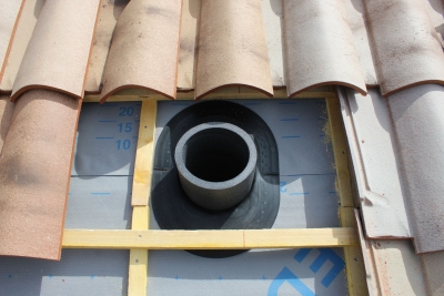 Membrane d'étanchéité fixée par adhésif intégré pour traiter le raccord étanche à l'air et à l'eau avec l'écran de sous toiture et isolation thermique pour éviter la condensation dans la gaine.JPG